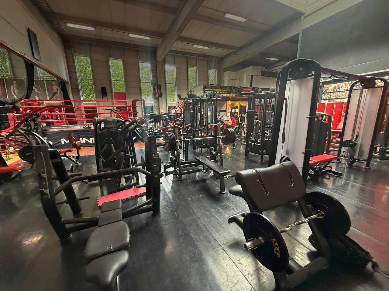 Krachtmachines op de fitnessvloer met de boksring op de achtergrond