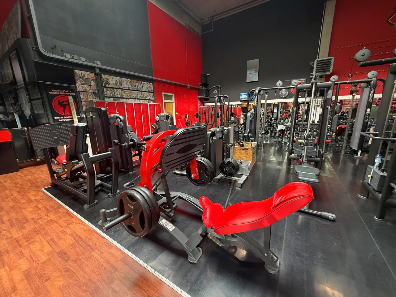 Rode plate-loaded krachtmachine op de fitnessvloer