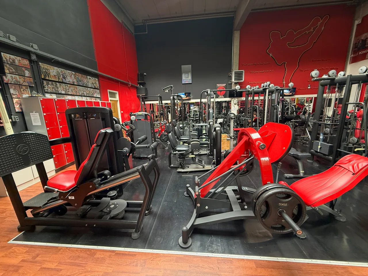 Plate-loaded machines met rode zittingen voor de lockerwand